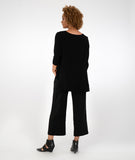 model in a black pant with a black top with a high-low hemline