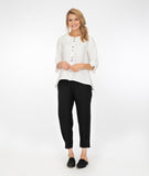 model in a white button down blouse with a flowy body and a slim leg black pant