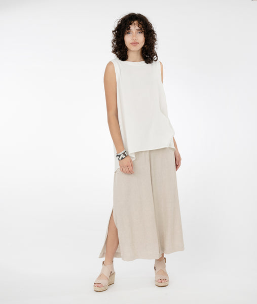 model in a long white tank, worn with a wide leg oatmeal color pant with a split at the side seams