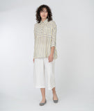 model in a grey, white and yellow striped top with a wide leg cropped white pant