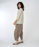 model in a yellow, white and grey striped asymmetrical top with a wide leg brown pant