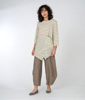 model in a yellow, white and grey striped asymmetrical top with a wide leg brown pant