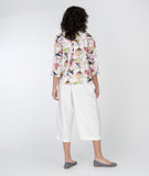 model in a white cropped pant with a floral print button down blouse