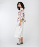 model in a white cropped pant with a floral print button down blouse