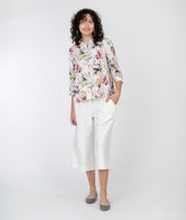 model in a white cropped pant with a floral print button down blouse