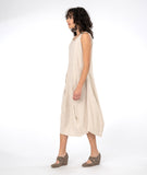 model in a sleeveless oatmeal color dress with tucks at the waist