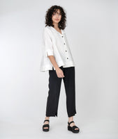 model in a white jacket with a slim black pant