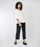 model in a white jacket with a slim black pant