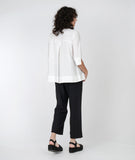 model in a slim black pant with a split at the ankle, with a boxy white button down