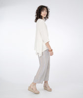 model in a wide leg striped pant with a white top with an angled hem