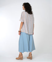 model in a pastel striped top with a wide leg blue pant