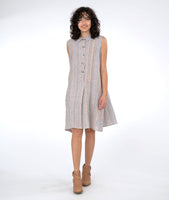 model in a sleeveless button up swing dress in a pastel stripe