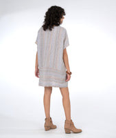 model in a boxy striped shift dress with a contrasting band across the bottom with pockets set in the seam