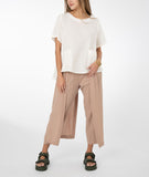 model in a white top with a khaki color pant with a draped side
