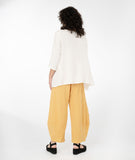 model in a yellow top with a hankerchief hem and a wide leg yellow pant 