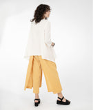 model in a white top with a yellow color pant with a draped side