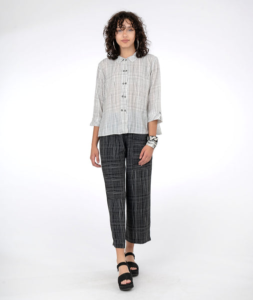 model in a black and white grid print pant with a matching white and black button down blouse