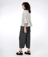 model in a black and white grid print pant with a matching white and black button down blouse