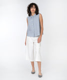 model in a sleeveless pinstriped button down top with a white wide leg cropped pant
