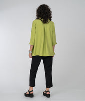 model in a slim black pant with a long button down blouse in lime