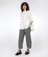 model in a black and white striped pant with a long, flowy white button down blouse