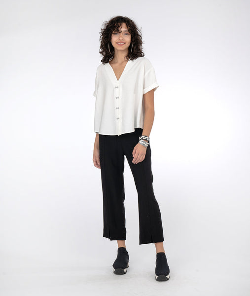 model in a slim black pant with a white short sleeve button down vneck top